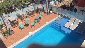 伊基托斯维多利亚雷吉亚酒店的享有带桌椅的游泳池的顶部景致