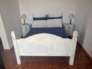 Comares万岁西班牙酒店的卧室内的一张白色床,设有2个床头柜
