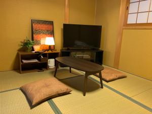 京都KYOTO SHIMA的客厅配有电视和茶几