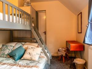 大莫尔文Eleri Cottage的一间卧室配有一张双层床和梯子