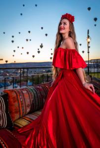 格雷梅Lord of Cappadocia Hotel的坐在沙发旁的红色衣服上的女人