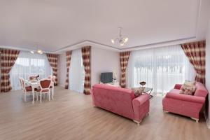 安塔利亚Onix Apart Hotel的客厅配有2张粉红色的沙发和1张桌子