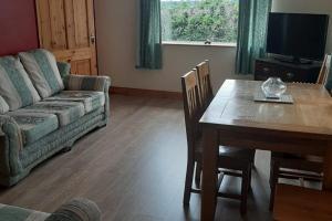 卡文Lovely Innishmore Island Farmhouse的客厅配有桌子和沙发