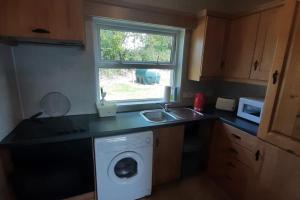 卡文Lovely Innishmore Island Farmhouse的厨房配有洗衣机和水槽