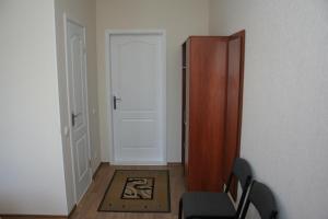 哈尔科夫亚历山大酒店的一间房间,设有门、椅子和地毯