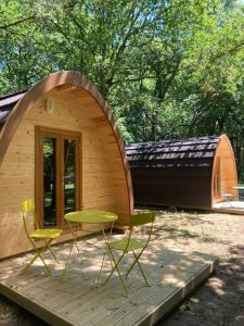 萨里亚Camping Vila de Sarria的小木屋设有1个带桌椅的甲板