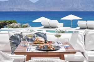 阿基欧斯尼古拉斯The Island Concept Luxury Boutique Hotel Heated Pool的一张桌子,上面放着一盘食物和酒杯