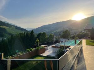萨尔巴赫Appartements Casa Nuova的享有带游泳池和山脉的房屋景致