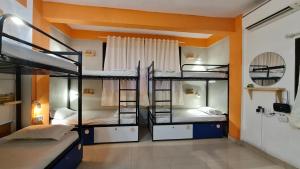浦那HOSHTEL99 - Stay, Cowork and Cafe - A Backpackers Hostel的一间设有三张双层床的客房