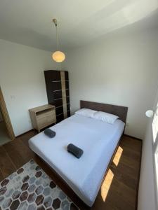 波德戈里察Entire 1-bedroom apartment with free parking的卧室配有一张白色大床,上面有两个黑色的物体