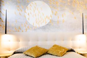 莱万托Bellevue - Rooms & Suites的一间卧室配有带2个金色枕头的床