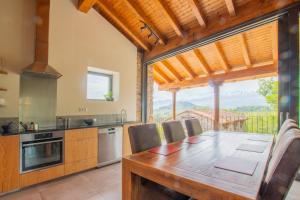 坎加斯-德奥尼斯Pulieru - Picos de Europa views, designed for all seasons的厨房配有木桌和大窗户。