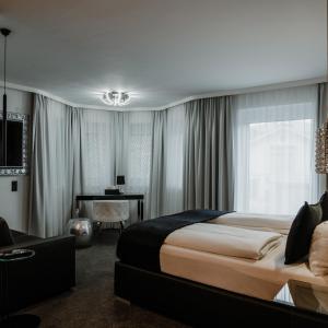 弗拉绍The Place Boutique & Design Hotel Flachau的酒店客房设有一张大床和一张书桌。