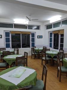 GushainiThe Mother's Riverfront的用餐室配有绿色的桌椅