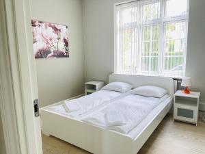 奥尔堡aday - 2 bedroom apartment with Patio的窗户客房内的一张白色床