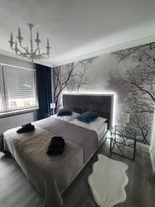 不莱梅R&S Apartments Bremen的卧室配有一张大床,墙上有树木