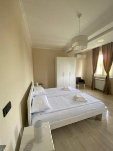 贝尔格莱德Vila Eleonora Beograd的卧室配有一张白色的大床和一张桌子