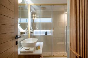 海若克利欧The Blossom-Premium living residence at Heraklion的一间带玻璃淋浴间和水槽的浴室