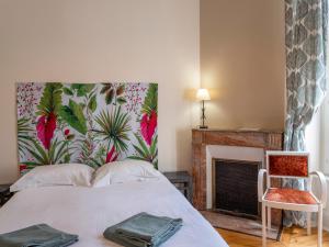 拉布尔布勒La Villa François Premier的一间卧室配有一张带花卉床头板的床和壁炉