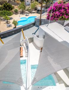 费拉Anila Suites的享有带遮阳伞的游泳池的景色
