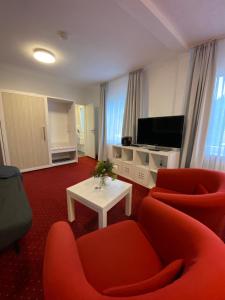 Hemfurth-EderseeHotel Pension Haus Talblick Edersee的客厅配有两把椅子和电视
