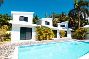 拉斯特拉纳斯Residence Las Dos Palmas的一座白色的房子,前面设有一个游泳池