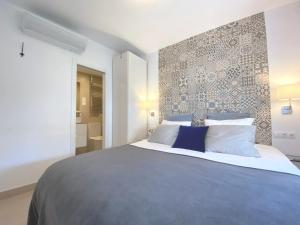 马拉加La Tierra Sur apartment Malaga Center的一间卧室设有一张带凸墙的大床