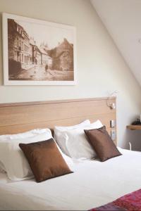 杜柏卡莱彻酒店的一张带白色枕头的床和一张墙上的照片