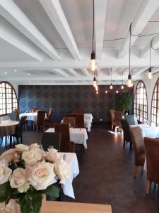 Saint-VianceL'Auberge的一间带桌椅和鲜花的用餐室