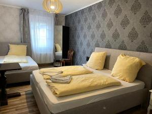 莱茵河畔林茨The Burgklause Boutique Hotel的一间卧室配有两张带黄床单的床