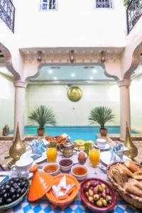 马拉喀什Riad Milouda的餐桌上的早餐桌,包括食物和饮料