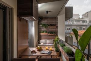 海若克利欧The Blossom-Premium living residence at Heraklion的阳台配有桌椅和沙发。