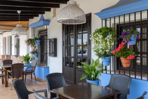 埃尔罗西奥Alojamiento Rural El Sombrero的一间设有桌椅和盆栽的餐厅