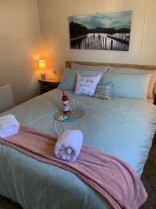 本布里奇Bliss Beach Lodge的一张带毛巾和一瓶葡萄酒的床