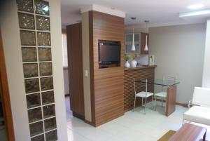 巴西利亚Flat Life Resort com serviço diário de limpeza的一间带电视和玻璃桌的客厅