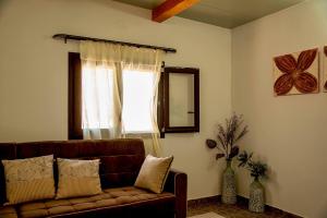 古卡斯特隆flamingo colour valey house的客厅设有棕色的沙发和窗户。