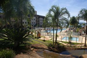 巴西利亚Flat Life Resort com serviço diário de limpeza的一个带游泳池和棕榈树的度假村