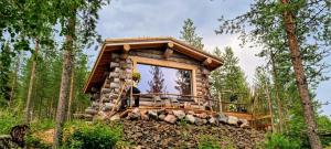 罗瓦涅米Cozy Log Cabin by Invisible Forest Lodge的树林中的小木屋,设有大窗户