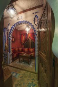 舍夫沙万切斯·阿齐兹公寓式酒店的客厅配有红色的沙发和桌子
