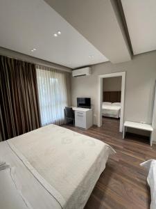 地拉那奥雷斯蒂中心酒店的一间卧室配有两张床和一张书桌