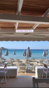 普拉迪斯亚罗斯Acrogiali Beachfront Hotel Mykonos的海滩上设有椅子和遮阳伞,还有大海
