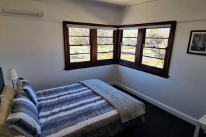 库马The Hermitage的一间卧室设有一张床和两个窗户。
