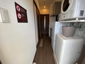 宫古岛HOTEL GranLeaf Miyakojima的洗衣房配有洗衣机和微波炉