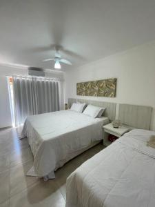 阿拉亚尔达茹达Casa em condomínio fechado-Arraial D'ajuda-Alto da Pitinga的一间卧室配有两张床和吊扇