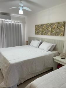 阿拉亚尔达茹达Casa em condomínio fechado-Arraial D'ajuda-Alto da Pitinga的一间卧室配有两张床和吊扇