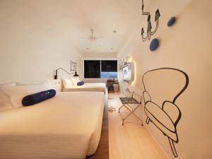 云顶高原Resorts World Genting - Genting SkyWorlds Hotel的卧室配有两张床和一张墙上的椅子。