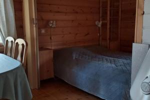 穆奥尼奥Mökki Jerisjärven rannalla的木制客房内的一间卧室,配有一张床