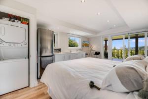 布伦特伍德湾Sea-esta Suite with Ocean Views in Brentwood Bay的一间白色卧室,配有一张大床和一个厨房