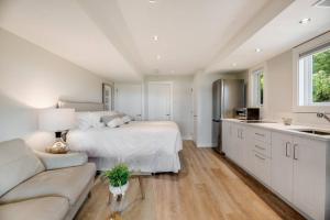 布伦特伍德湾Sea-esta Suite with Ocean Views in Brentwood Bay的一间白色的大卧室,配有一张床和一张沙发