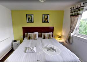 海伦斯堡考迪酒店的一间卧室,配有一张床,上面有安宁的标志